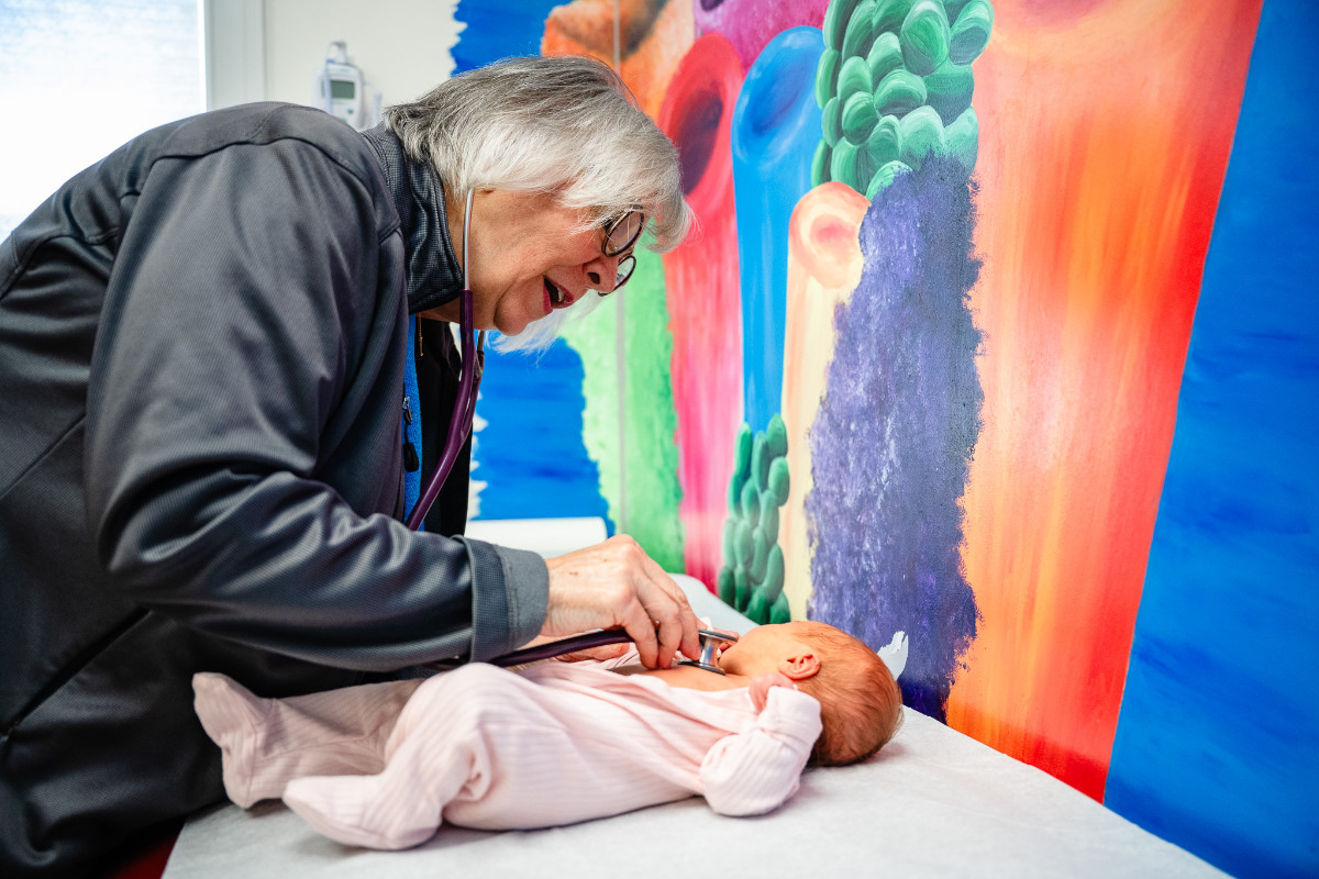 a doctor using a stethoscope with an infant